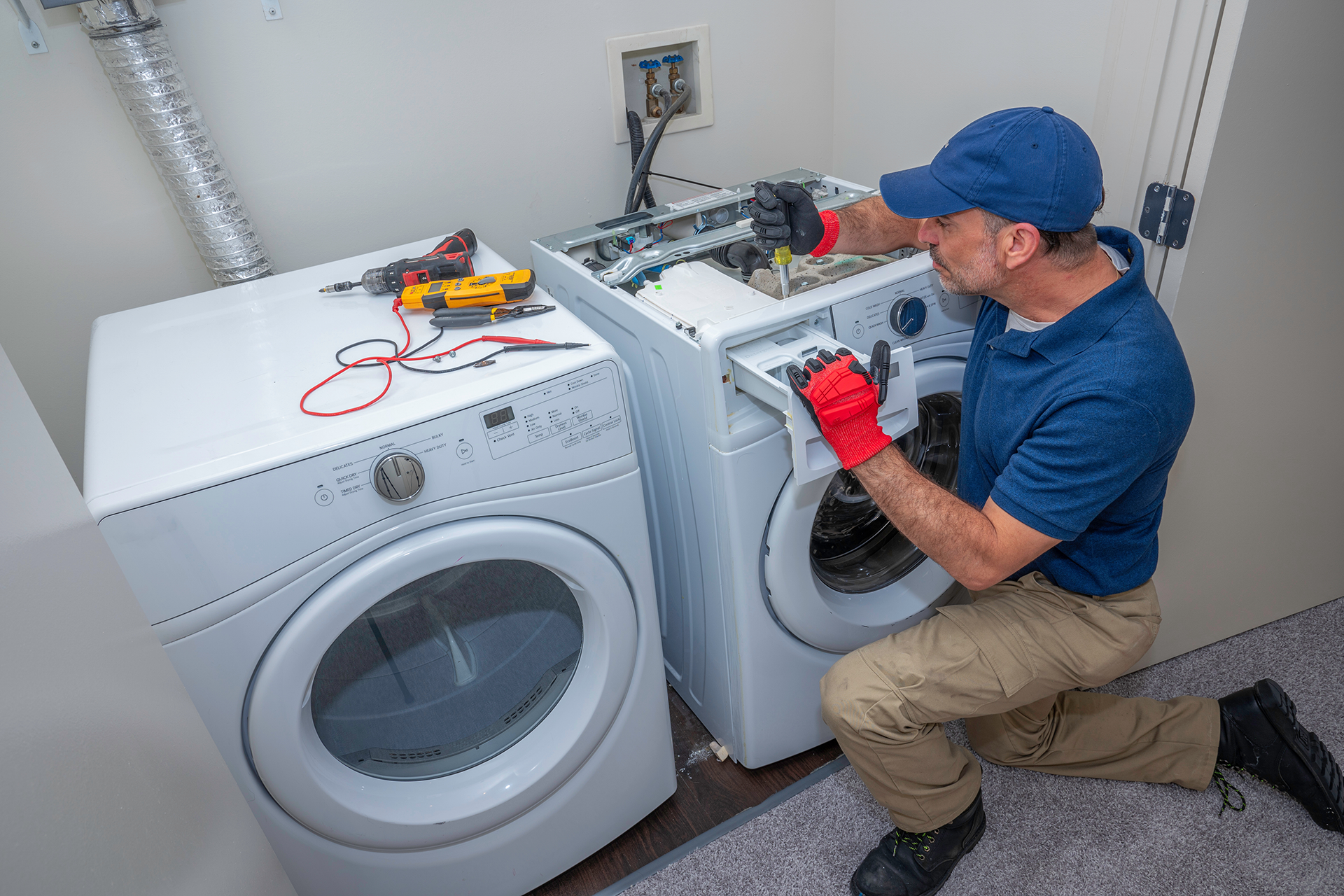 Technician repairing washer & dryer